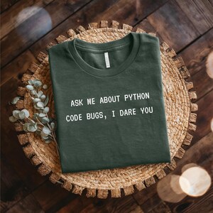 May include Dark green t shirt with the text ASK M