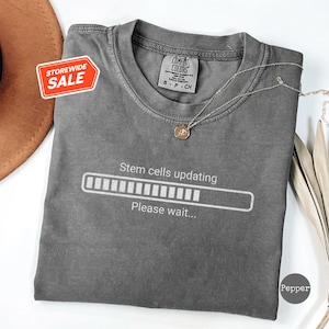 May include Gray t shirt with a white loading bar 