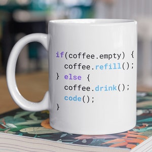 May include White ceramic coffee mug with a blue a